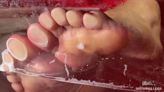 Mistress'_s wet wrinkled soles are pressed against the glass in the bathtub Thumb