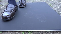 Girl making shoe prints on black board Thumb