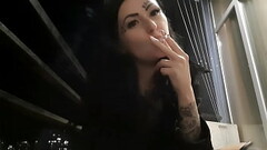 Dominatrix Nika smokes sexy in the evening on her balcony and blows smoke in your face. Thumb